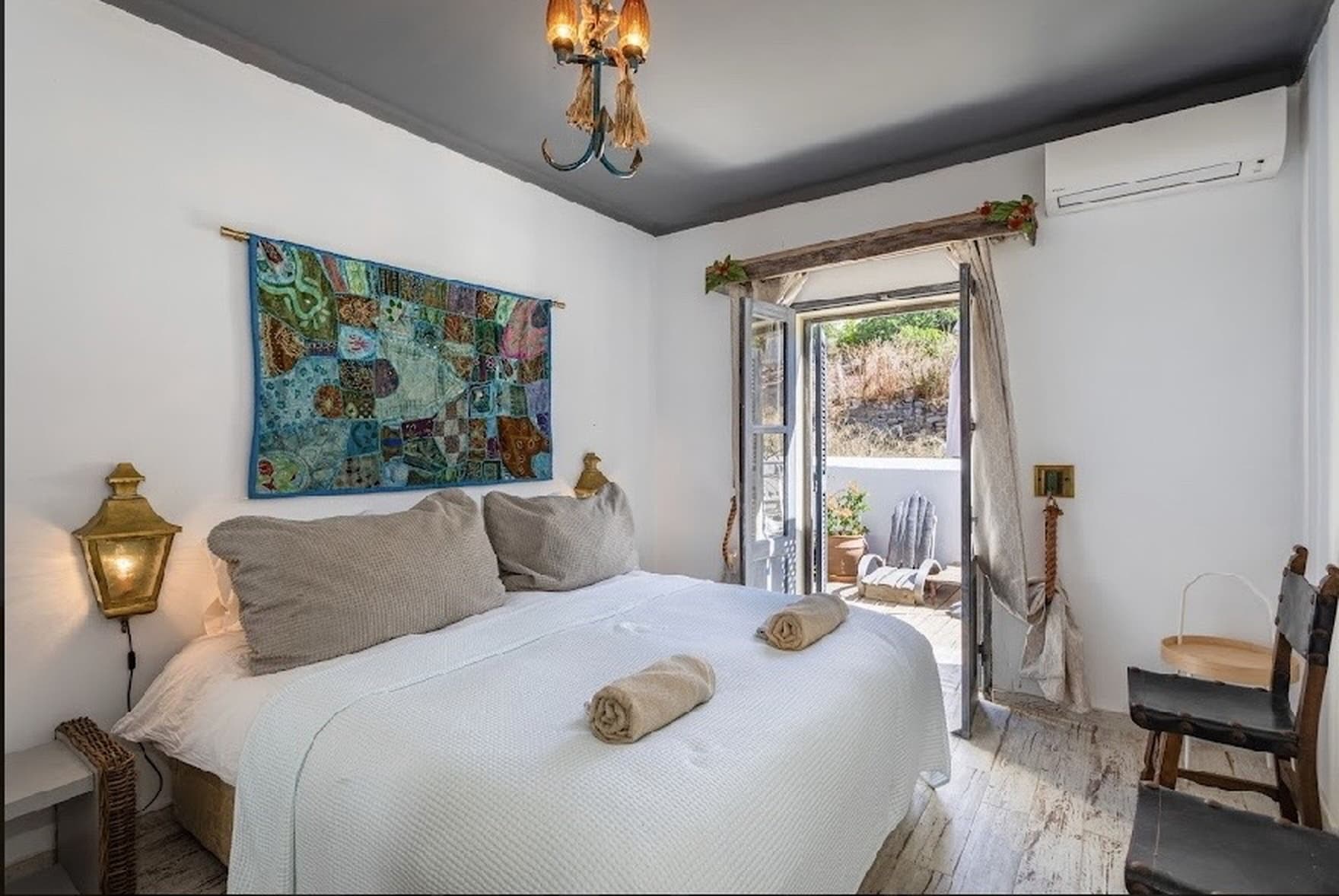 Queen bedroom with patchwork wall art and private terrace door