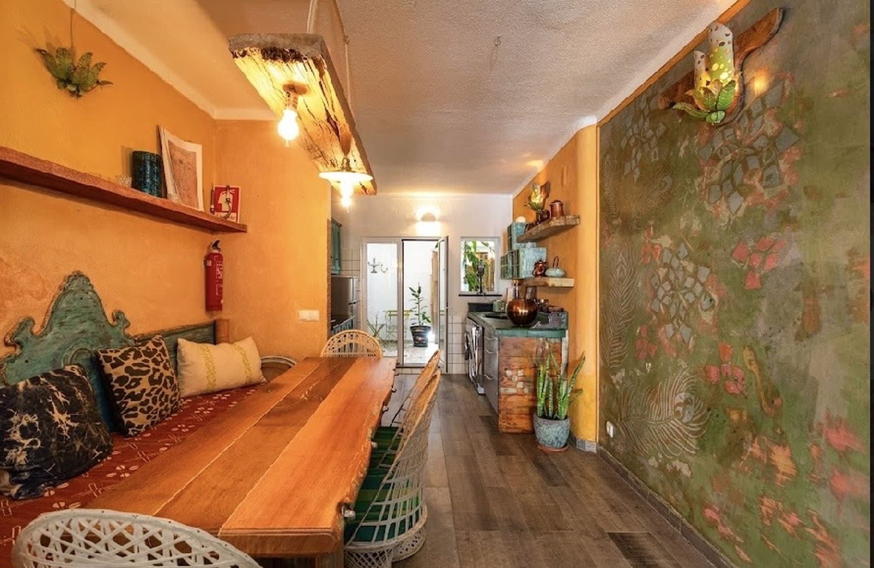 Dining area with long wooden table and mural wall