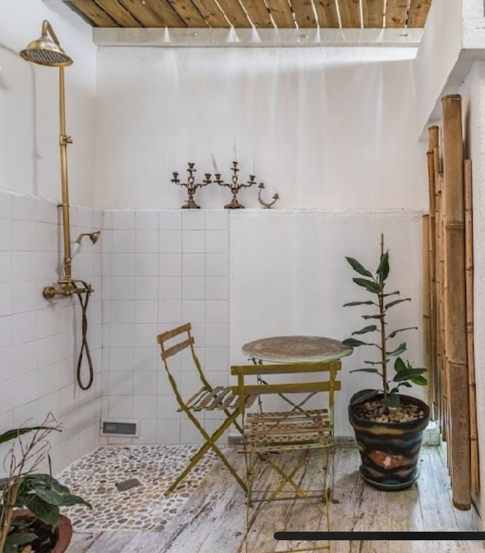 Outdoor shower with brass fixtures, candelabra and bamboo