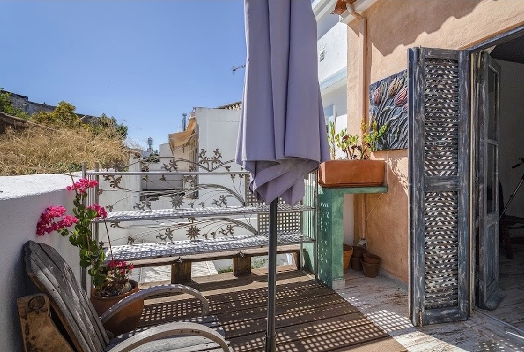 Front terrace with ornate ironwork door and pink bougainvillea